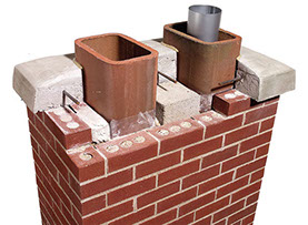 This photo shows a chimney with a section cut out to make the different parts of the chimney visable. The flues are seen inside the bricks & cap