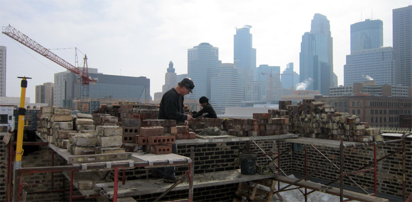 A view from a rootop downtown Minneapolis as Tim and his crew make repairs. Minneapolis skyline in the background.