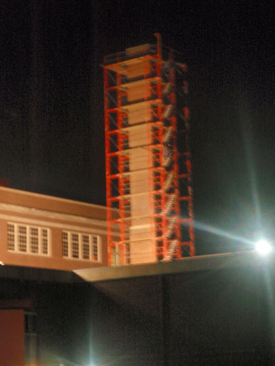 The scaffolding constructed around the large chimeny we took down and completely rebuilt, lit up at night by flood lights.