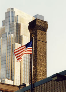 A chimney downtown that we repaired the top several courses and tuckpointed the remainder of the chimney. American flag in foreground.